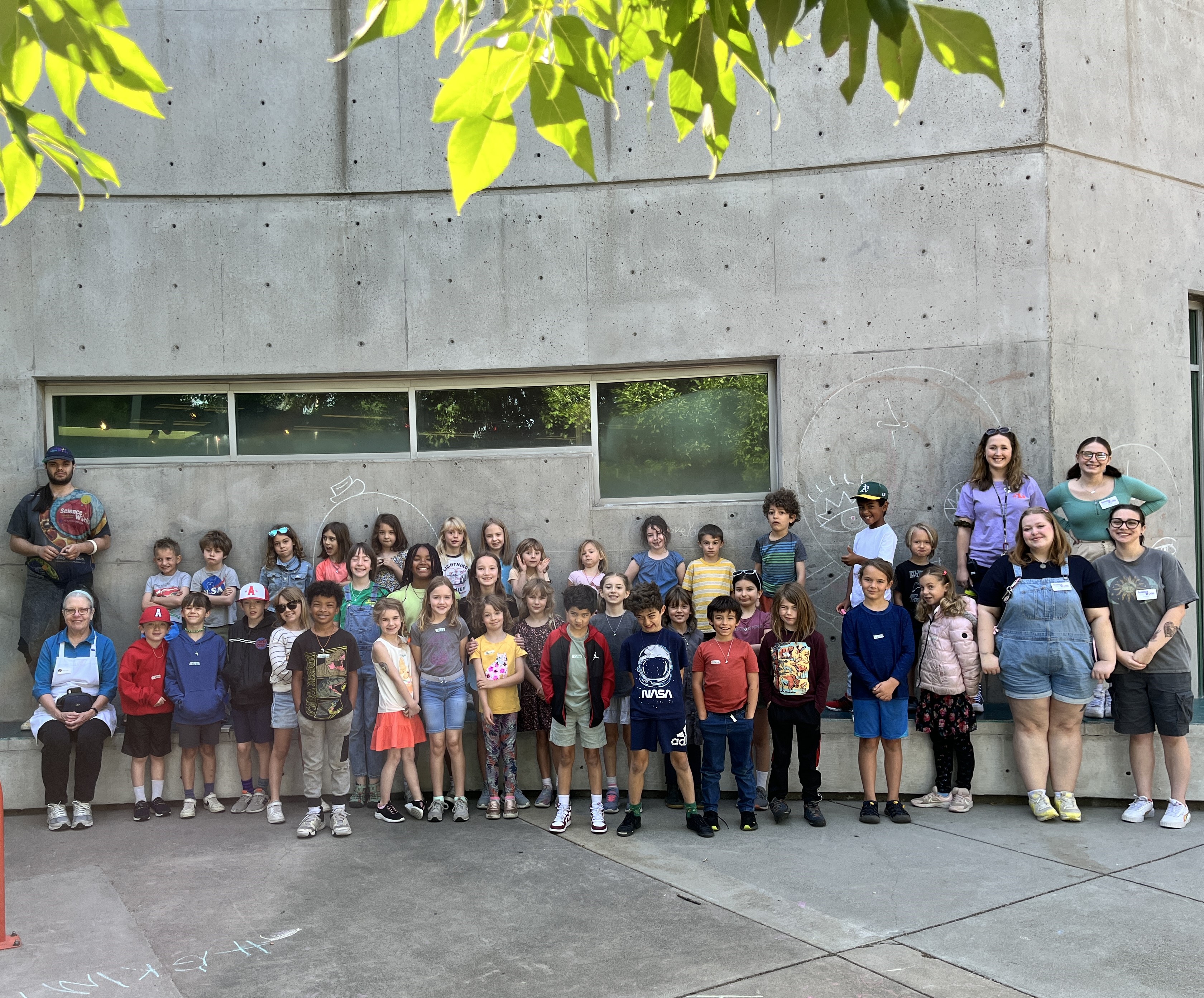 Summer camp students and instructors posed in front of ScienceWorks