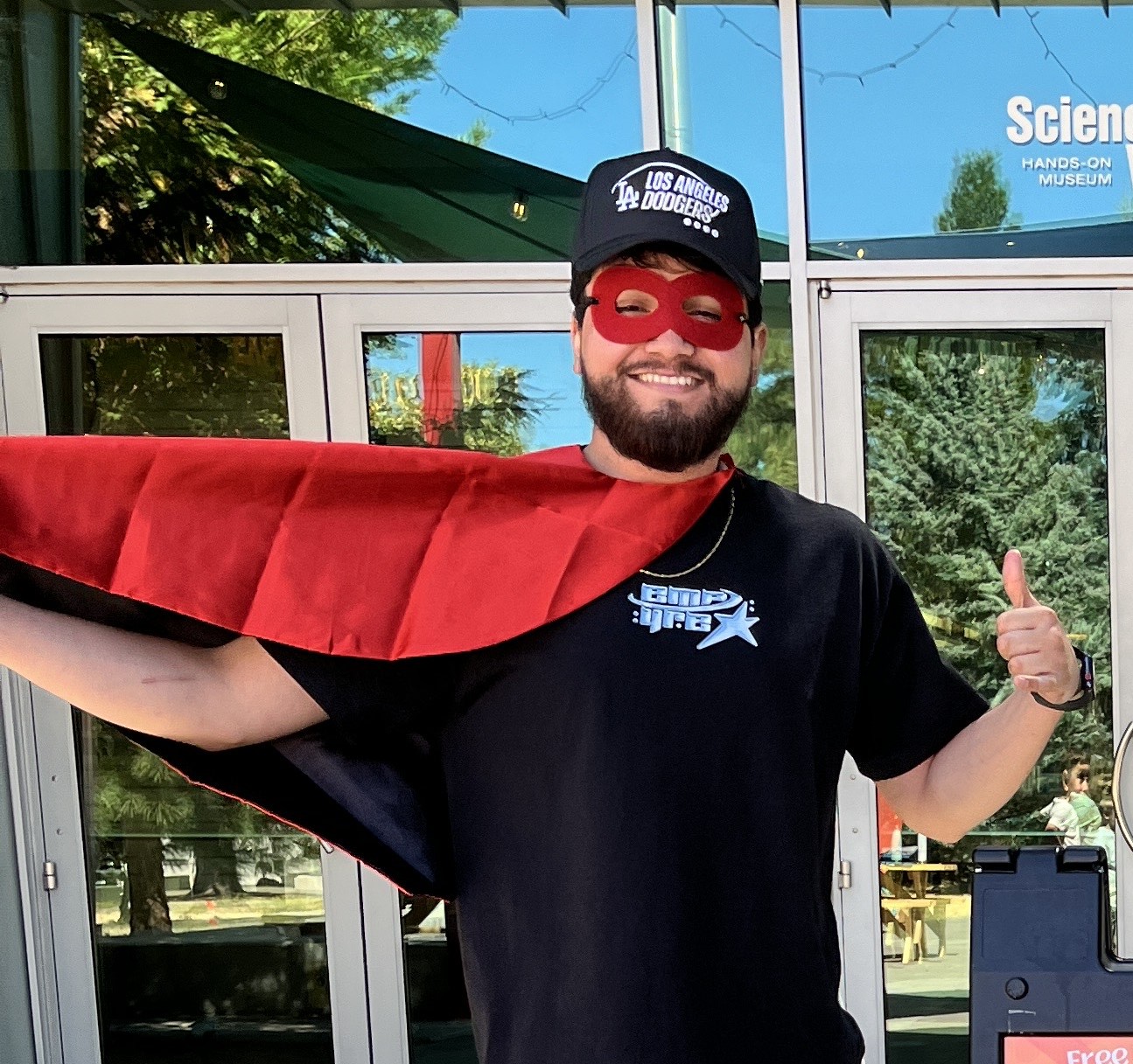 ScienceWorks Staff member posing in a superhero cape